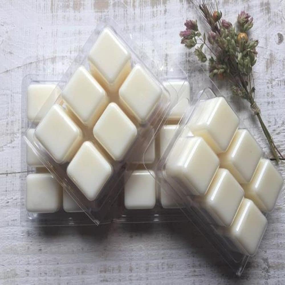 Fragrance oil being poured into a metal container during candle making